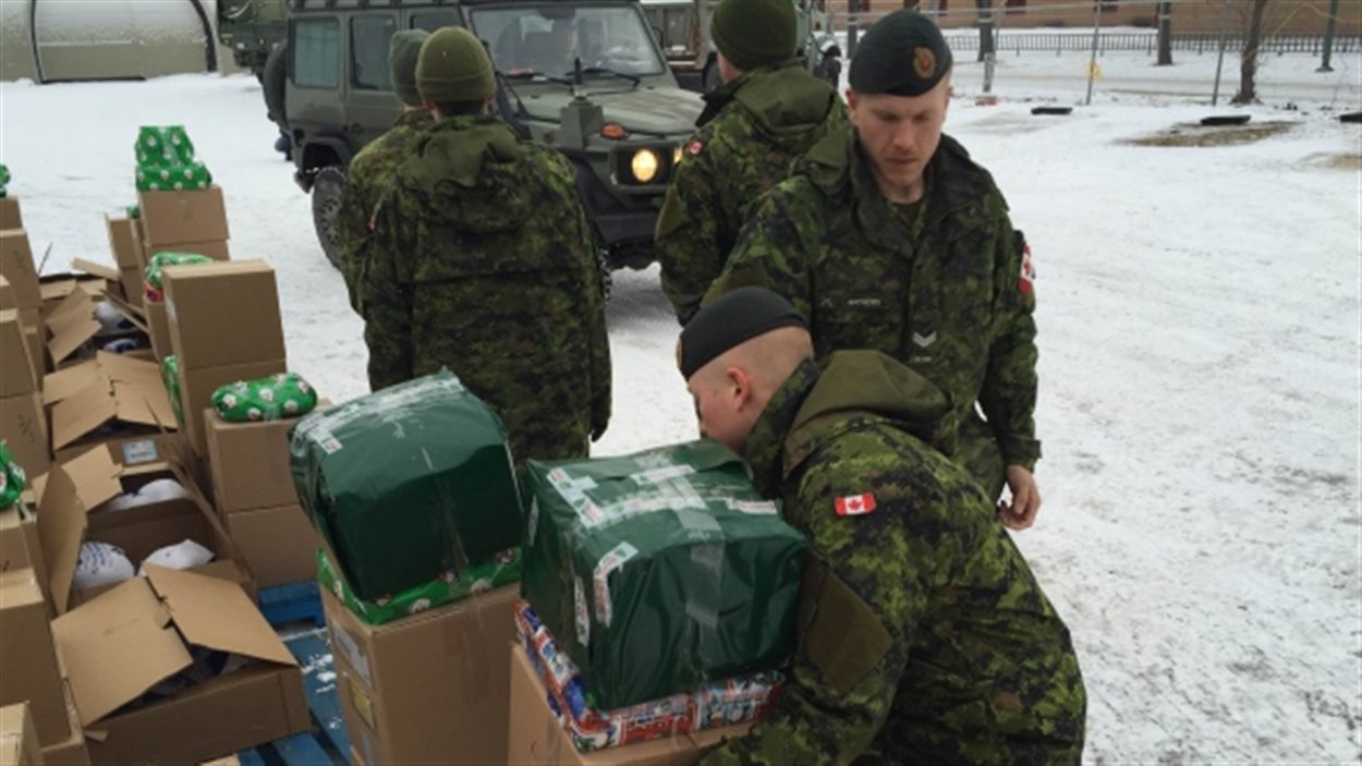 Des militaires apportent des cadeaux de Noël dans le quartier North End de Winnipeg.