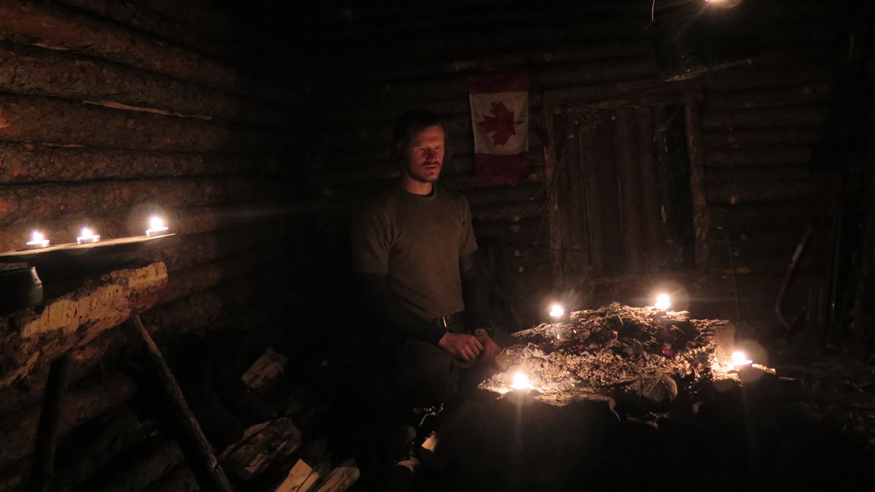Kristoffer Glestad à l'intérieur de sa cabane avec des chandelles