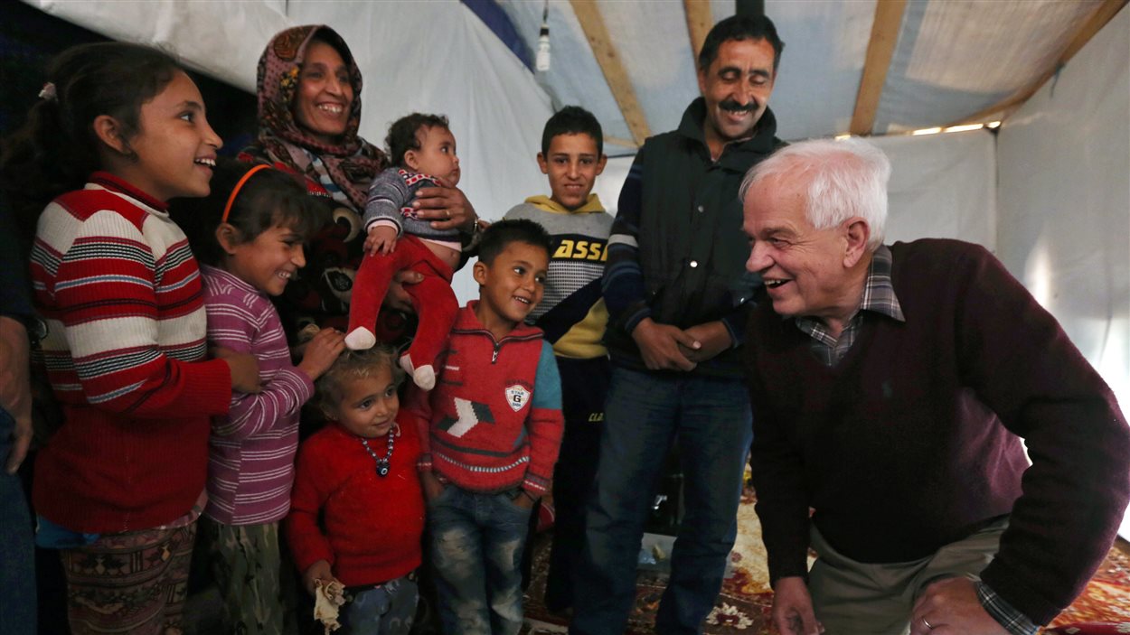 Le ministre John McCallum et des réfugiés syriens dans un camp, au Liban