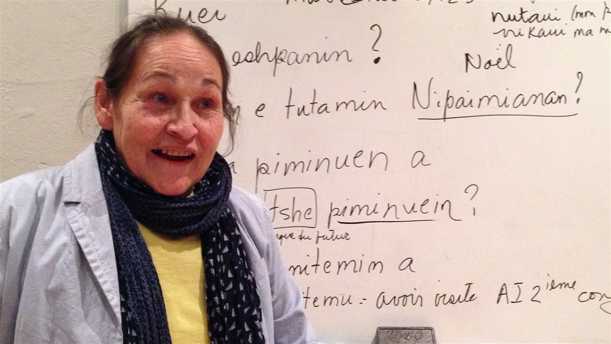 La poétesse et professeure d'innu Joséphine Bacon écrit au tableau et fait répéter une dizaine d'élèves.