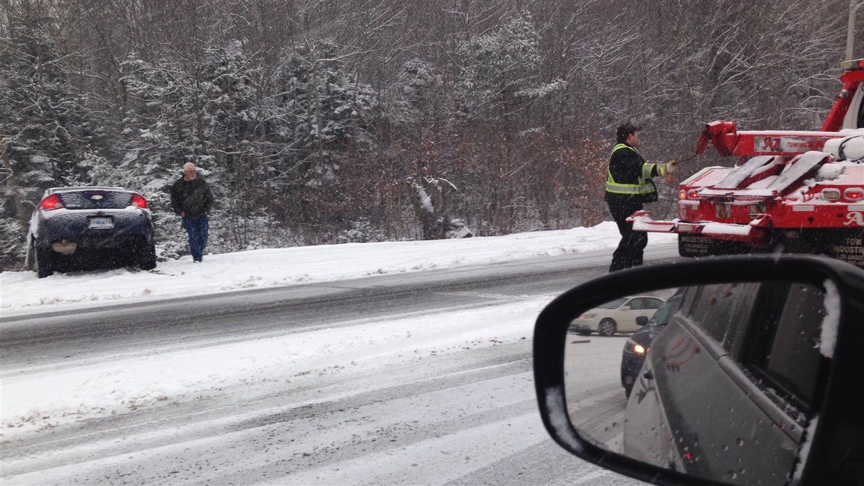 Une dépanneuse se prépare à venir en aide à un chauffeur qui a fait une sortie de route.