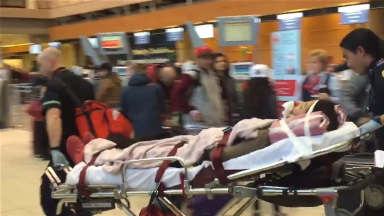 Un des passagers transportés en civière à l'aéroport de Calgary.