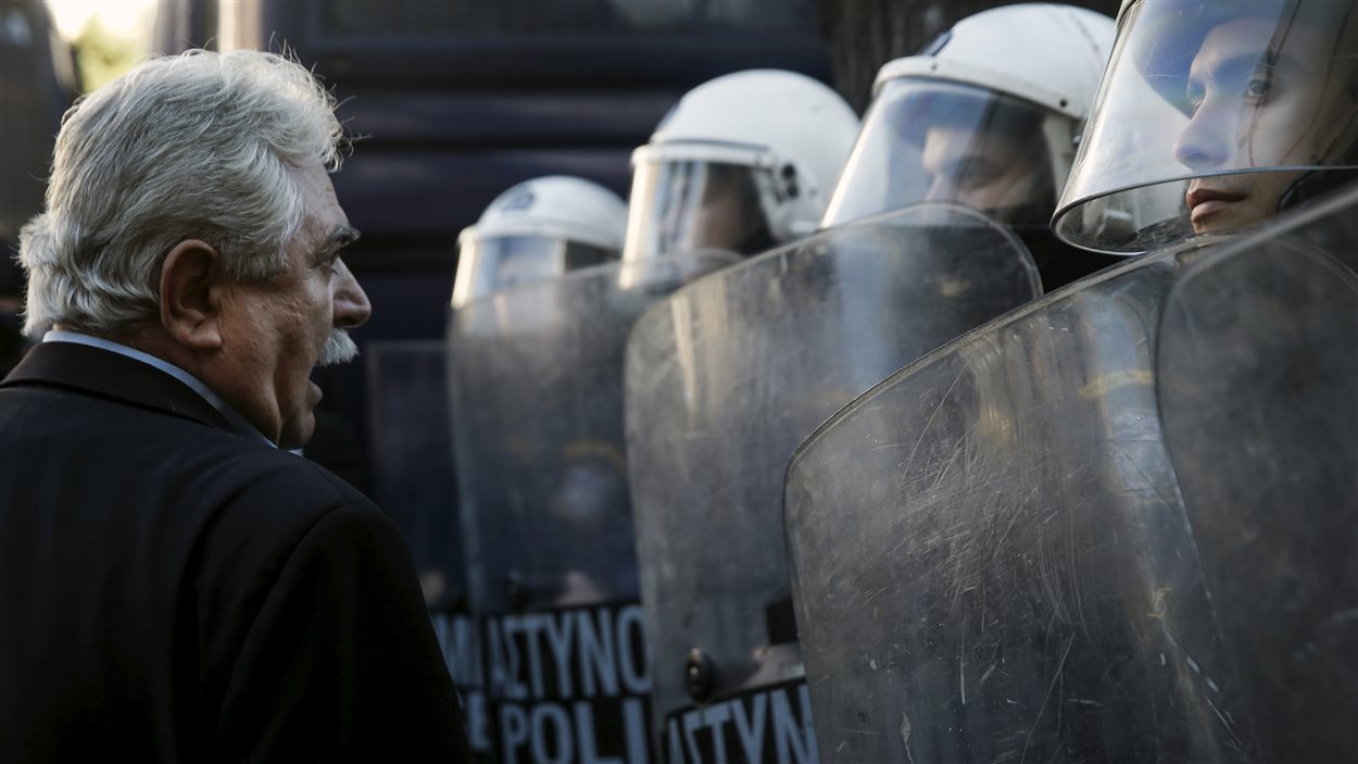 Le député grec Alkis Konstantindis confronte des policiers grecs lors d'une manifestation contre le projet de retraite du gouvernement.