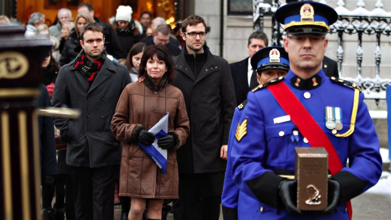 La femme de Jean-Paul L'Allier, Johanne Mongeau, marche derrière l'urne qui contient les cendres de son mari à la fin des funérailles