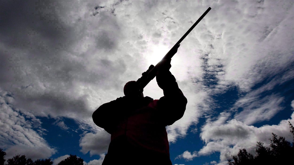 Un homme vérifie son fusil de chasse dans un camp de chasse ontarien.