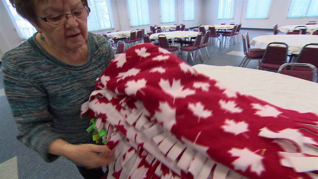 À l’église Saints-Martyrs-Canadiens de Winnipeg, des bénévoles sont occupés à fabriquer des couvertes pour de jeunes réfugiés syriens.