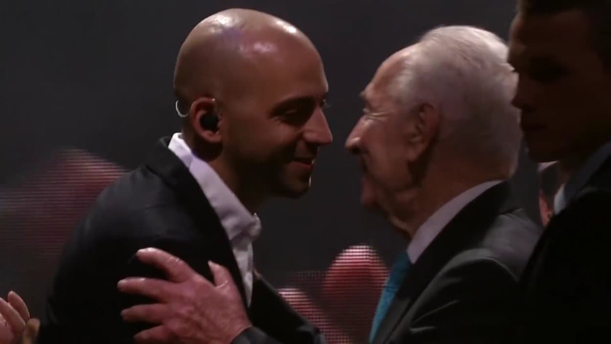 Concert à Tel-Aviv, le 5 février 2015. M. Shimon Peres, 9e président de l'État d'Israël, félicite Idan Raichel : « Un jour viendra ou nous traverserons le temps, passant de la guerre à la paix, et si quelqu'un ne sait pas comment faire, je lui montrerai le pont qu'Idan a construit. »
