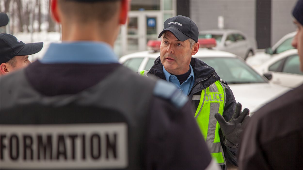 L'instructeur de l'École nationale de police du Québec à Nicolet, Martin Destrempes avec des aspirants policiers en discussion après une simulation.