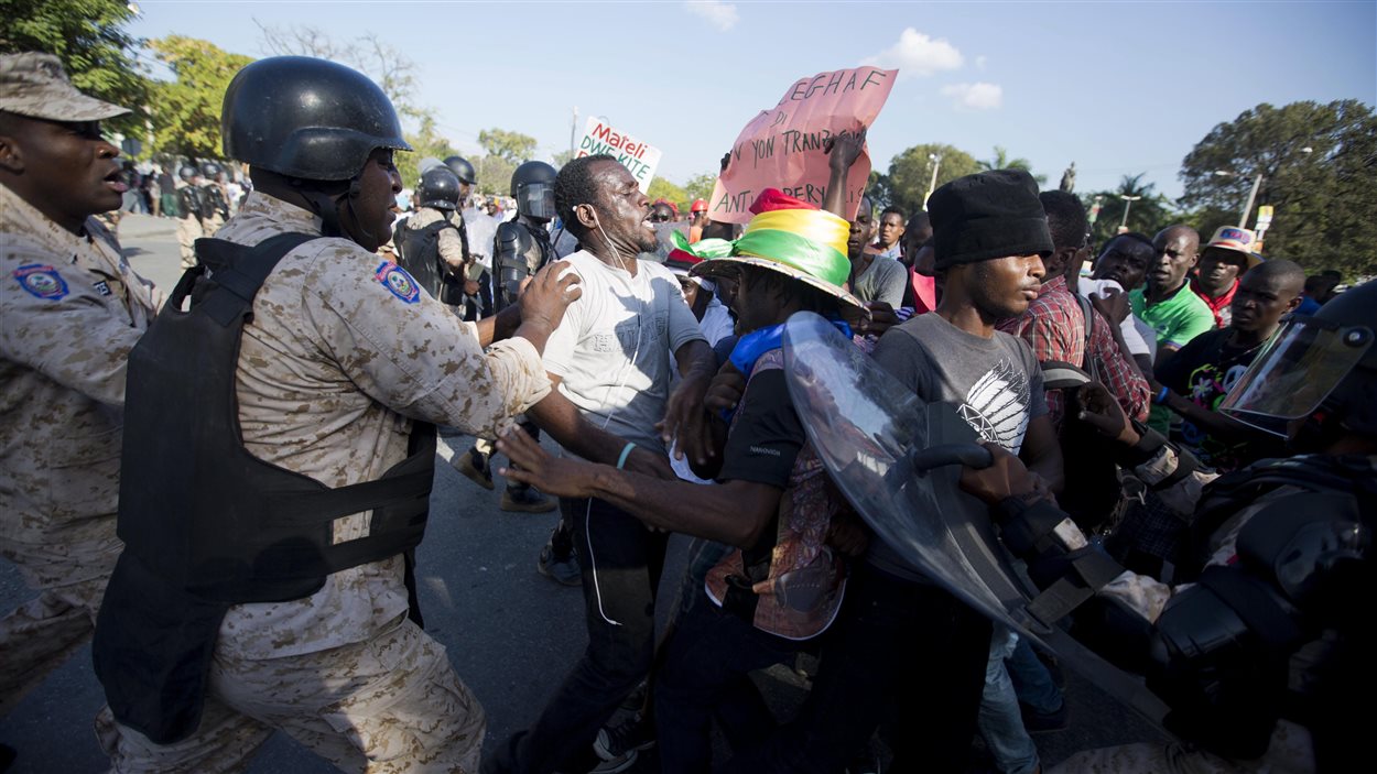 La police nationale tente de contenir une manifestation d’opposants au président sortant Michel Martelly, devant le Palais national à Port-au-Prince vendredi, le 29 janvier 2016.