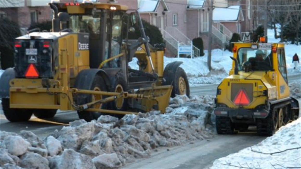 Une équipe de déneigement est constituée d'un souffleur, d'une niveleuse, d'une chenillette à trottoirs, d'un véhicule de sécurité et de camions de transport de la neige.
