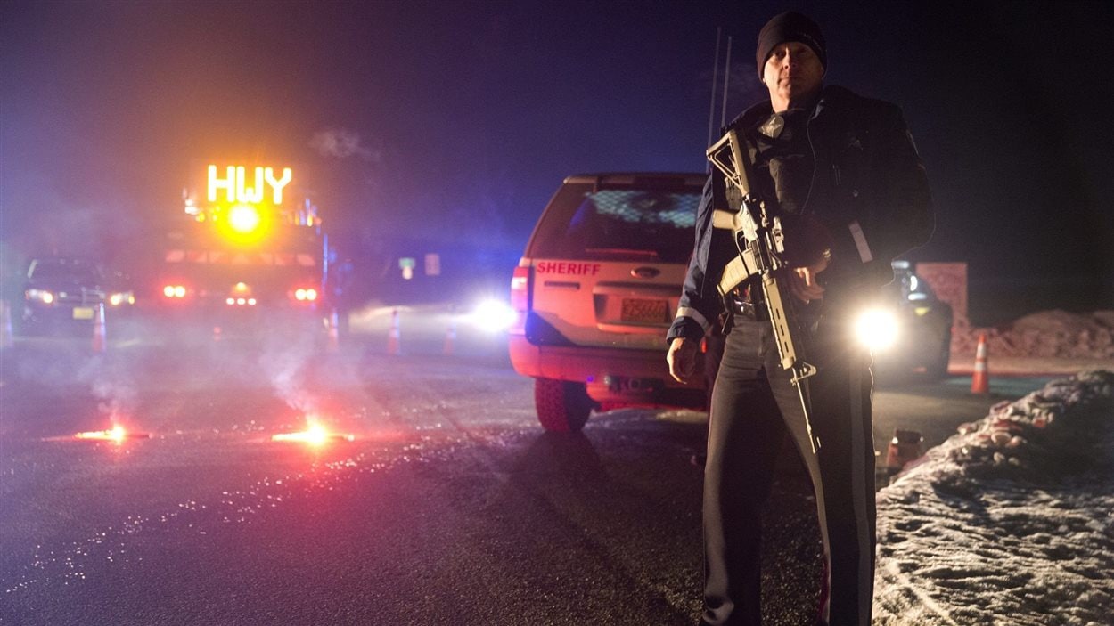 Un policier se tient devant un barrage routier, lors de l'opération policière contre la milice armée près de Burns, en Oregon.