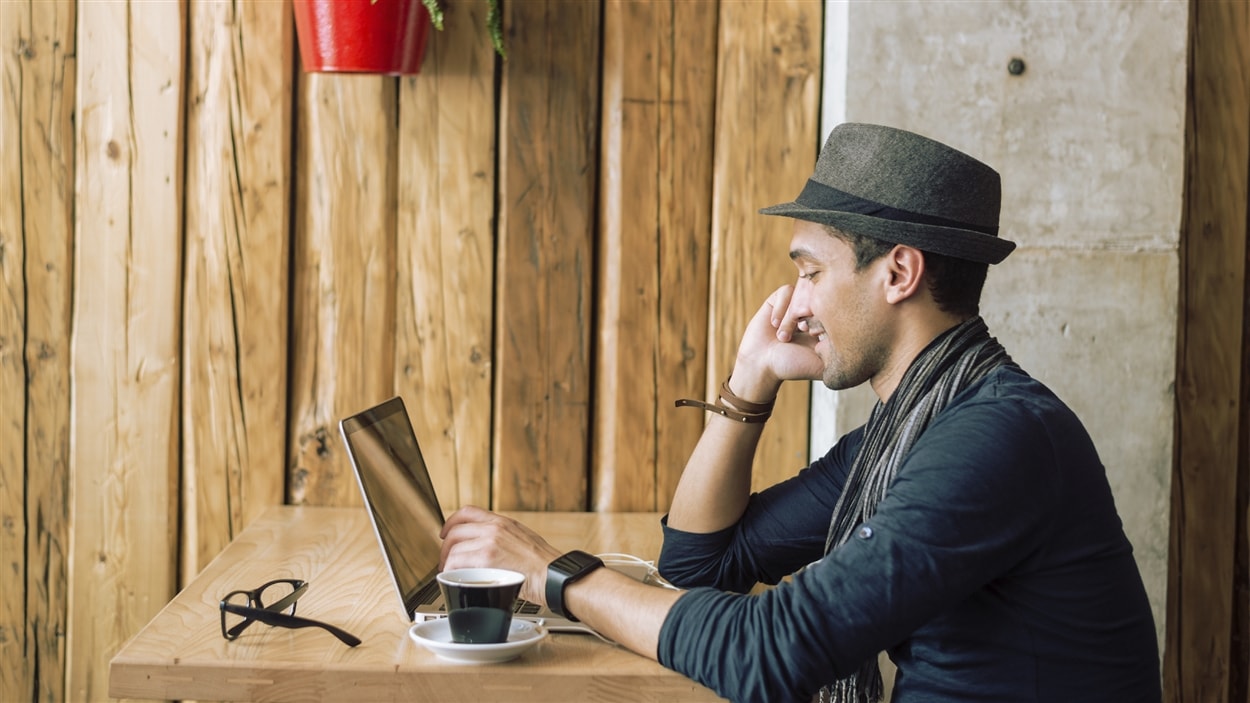Un jeune homme travaille sur un ordinateur portable.