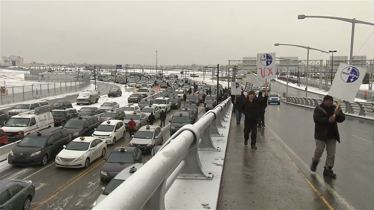 Les taxis bloquent la voie qu'ils empruntent normalement pour aller chercher des clients à l'aéroport. La voie qui permet aux taxis de déposer des clients est libre cependant.