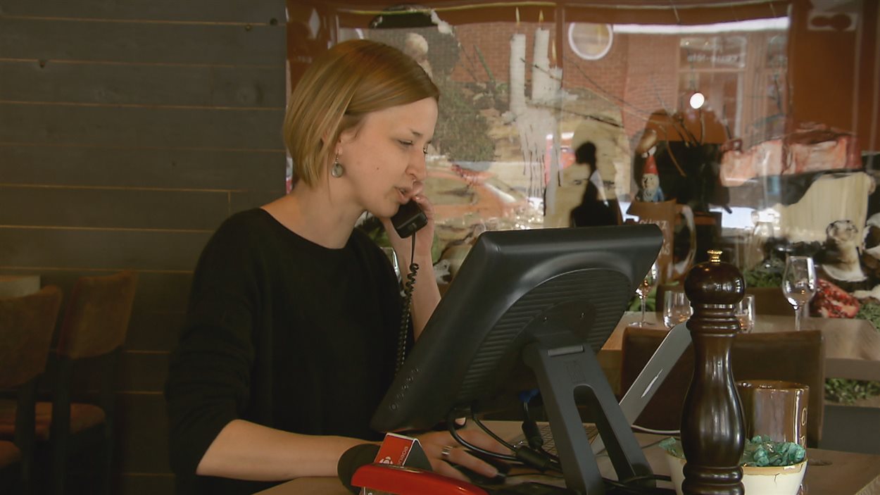 Une femme répond à un appel dans un restaurant.