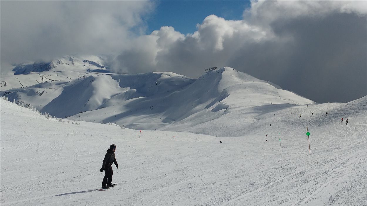 Un planchiste évolue le long d'une piste à Whistler