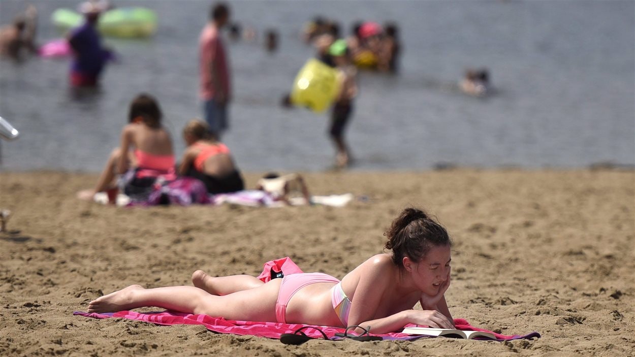 Une femme en train de prendre un bain de soleil à la plage de Mooney's Bay en août 2015.