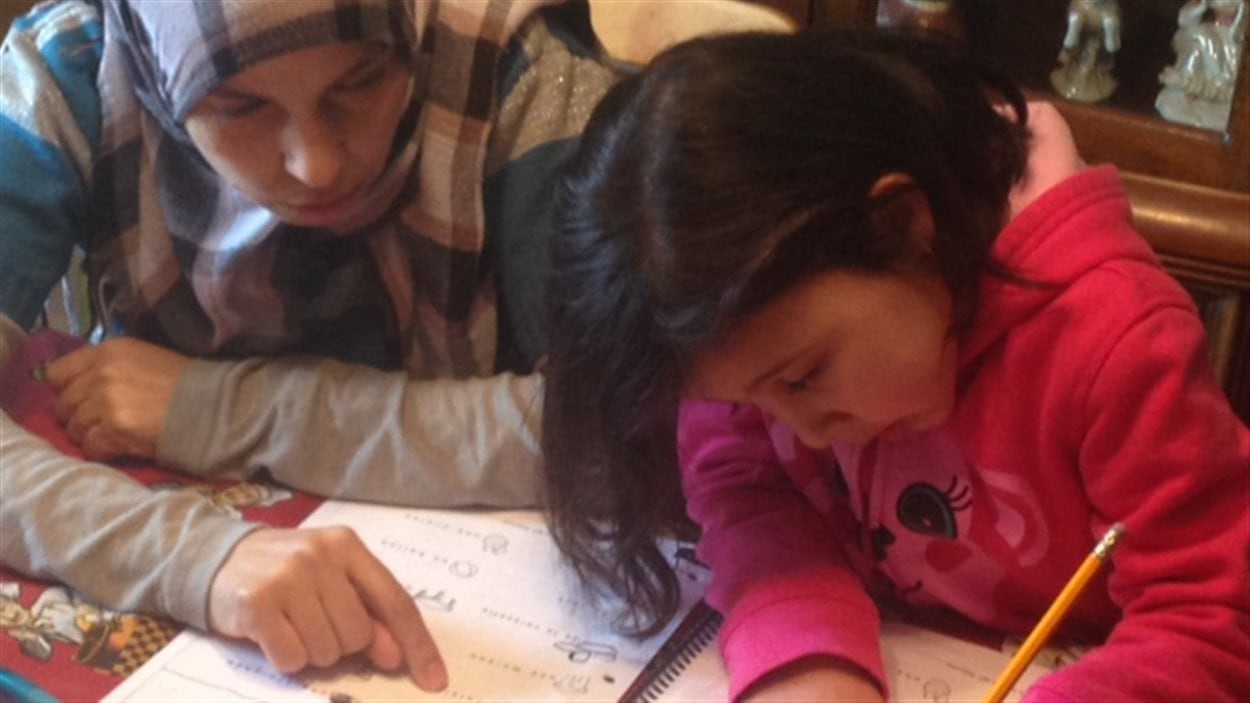 La petite de cinq ans fait ses devoirs avec sa mère.