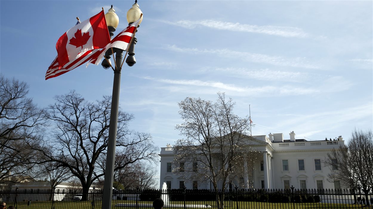 Les drapeaux canadien et américain flottent devant la Maison-Blanche, le 7 mars 2016.
