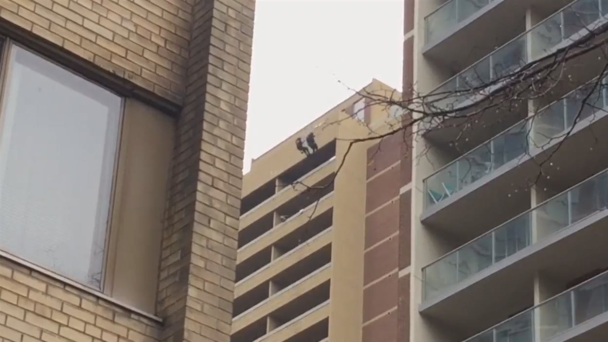 Deux policiers descendent du haut d'un hôtel pour arrêter l'accusée.