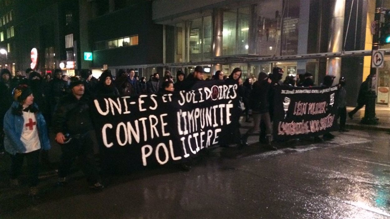 Des manifestants opposés à la brutalité policière sur la rue Sainte-Catherine, à Montréal