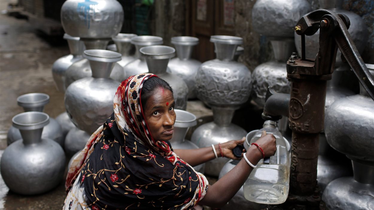 Une femme remplit une cruche d'eau à partir d'une pompe manuelle à Dhaka, au Bangladesh.
