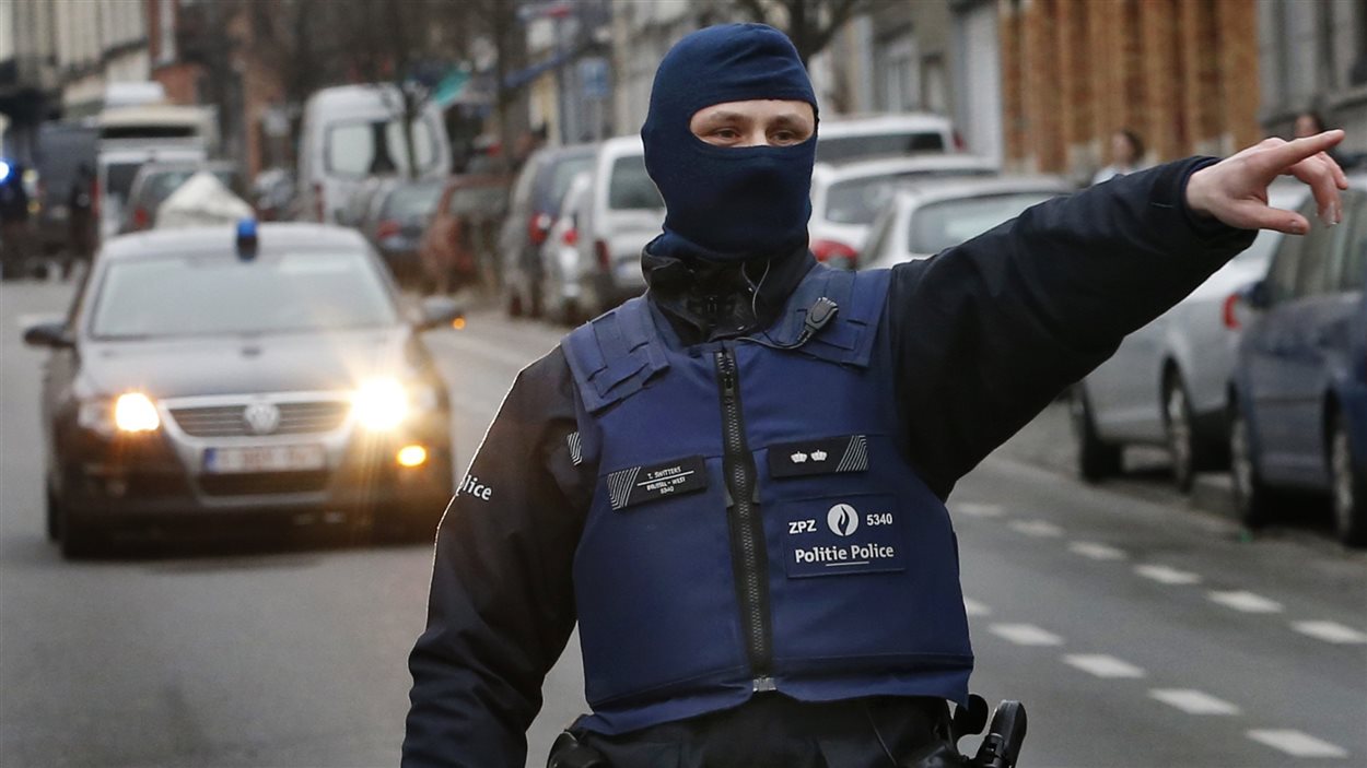Un policier dans la connune de Molenbeek, près de Bruxelles, pendant une vaste opération pour retrouver Salah Abdeslam