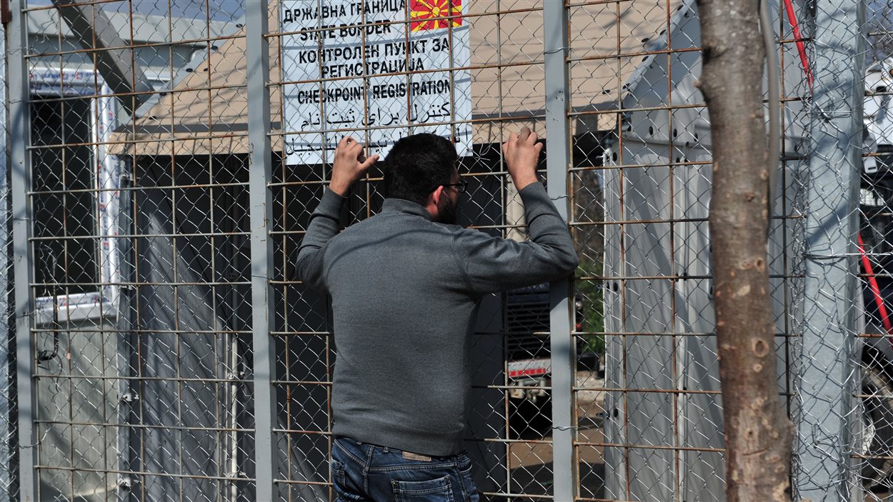 Un migrant coincé en Grèce depuis la fermeture de la route des Balkans s'appuie sur la clôture qui l'empêche d'entrer en Macédoine.