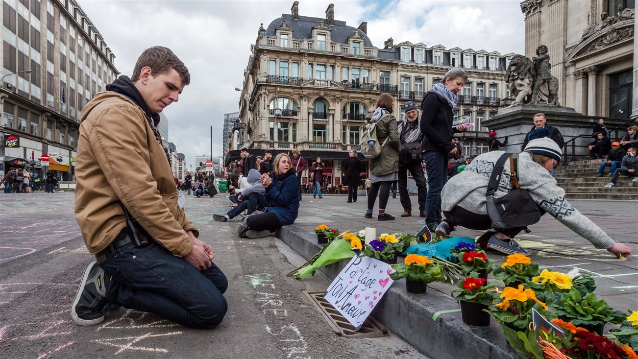 Un homme regarde des messages laissés à la mémoire des victimes des attaques de Bruxelles.