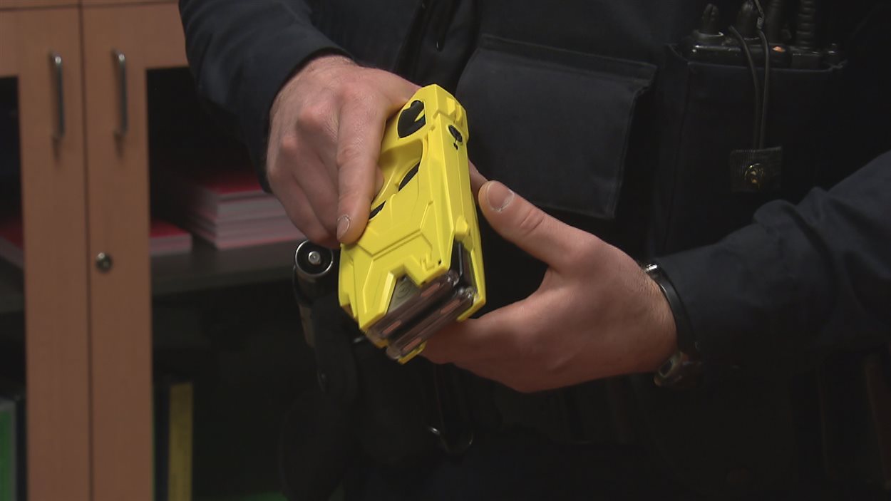 Un policier tient un pistolet Taser