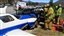 Des secours s'affairent autour d'un petit avion entré en collision avec une voiture sur l'autoroute I-15 en Californie, le 2 avril 2016. 
