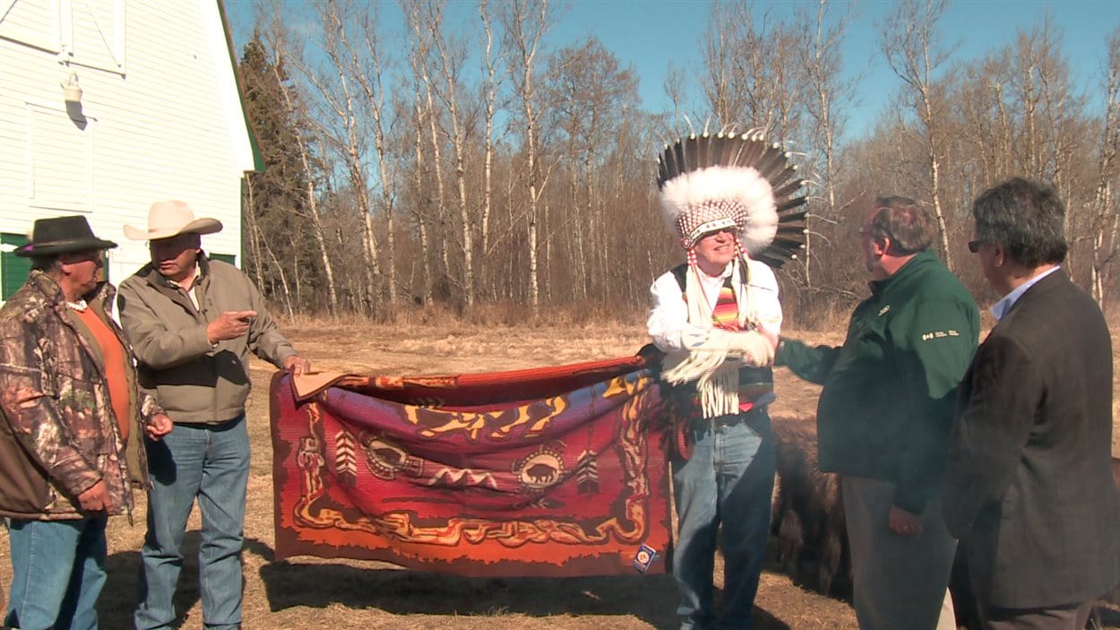 Le président du conseil tribal de la nation Blackfeet  serre la main du surintendant du parc national Elk Island, Stephen Flemming.