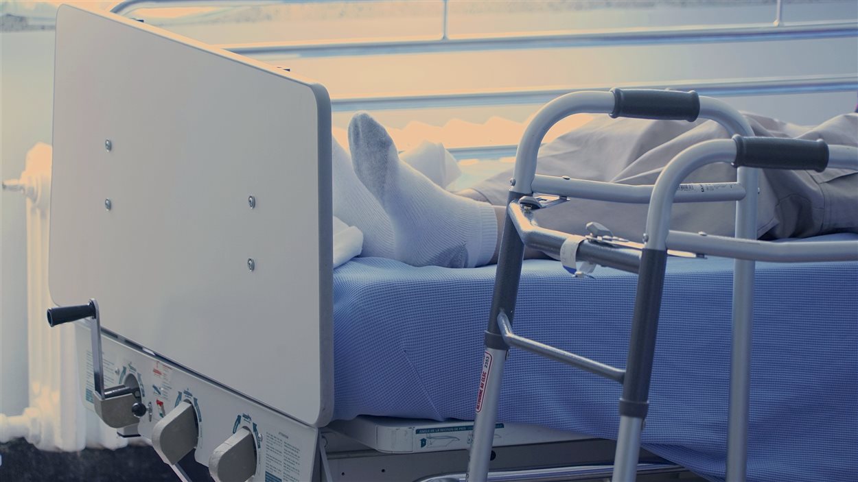 Une personne âgée étendue sur un lit de soins de longue durée à l'hôpital de Baie-Comeau.