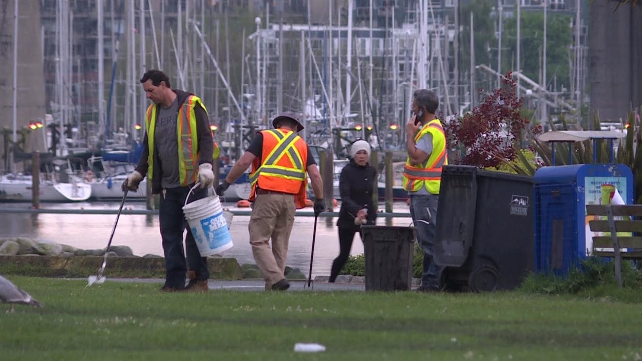 Des employés de la Commission des parcs de Vancouver ramassent les déchets de l'événement 4/20 à la plage Sunset.