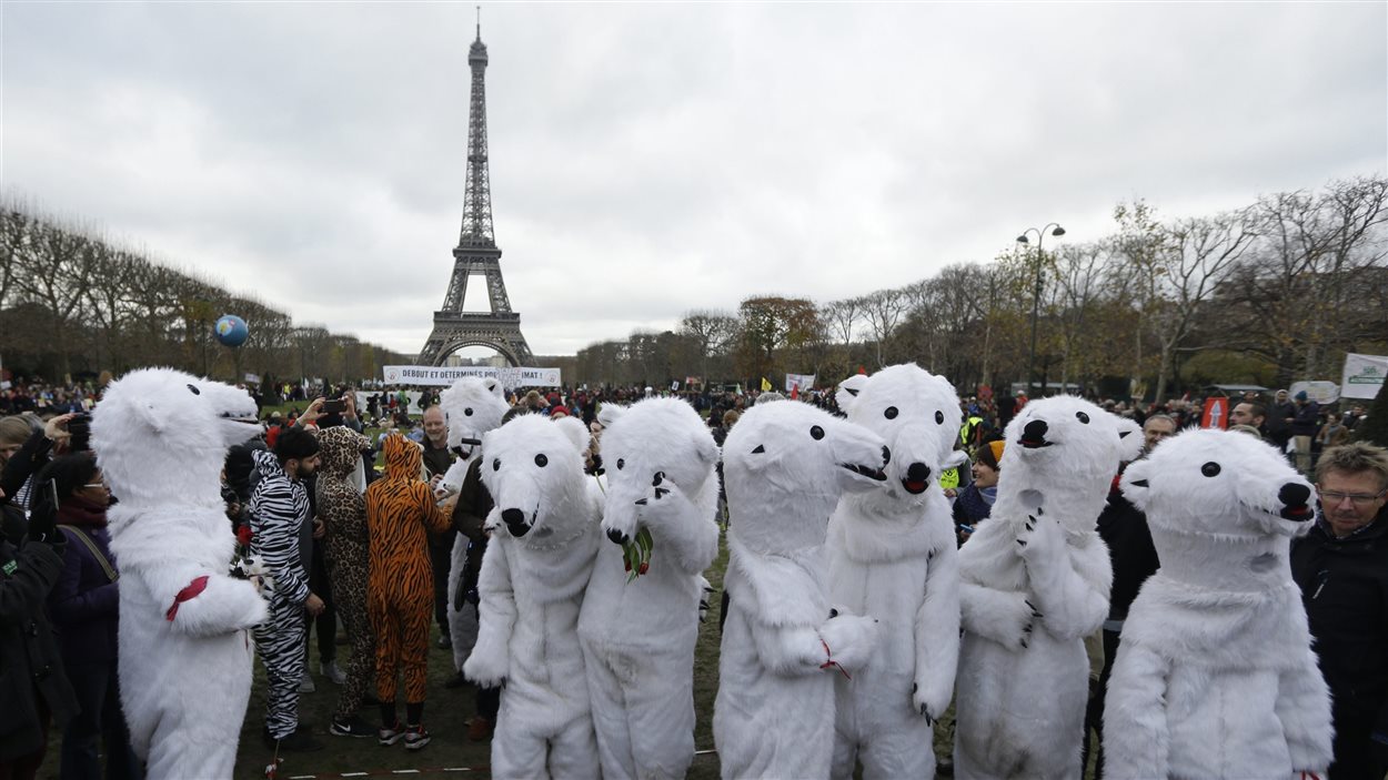 Des environnementalistes se sont rassemblés à Paris alors que les organisateurs du sommet sur le climat présentaient leur projet d'accord final en décembre 2015.