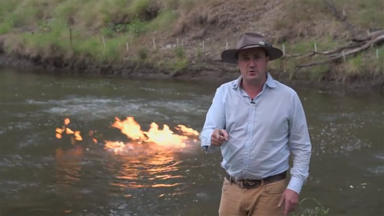 Le député australien Jeremy Buckingham, devant le feu qu'il a allumé sur la rivière Condamine.