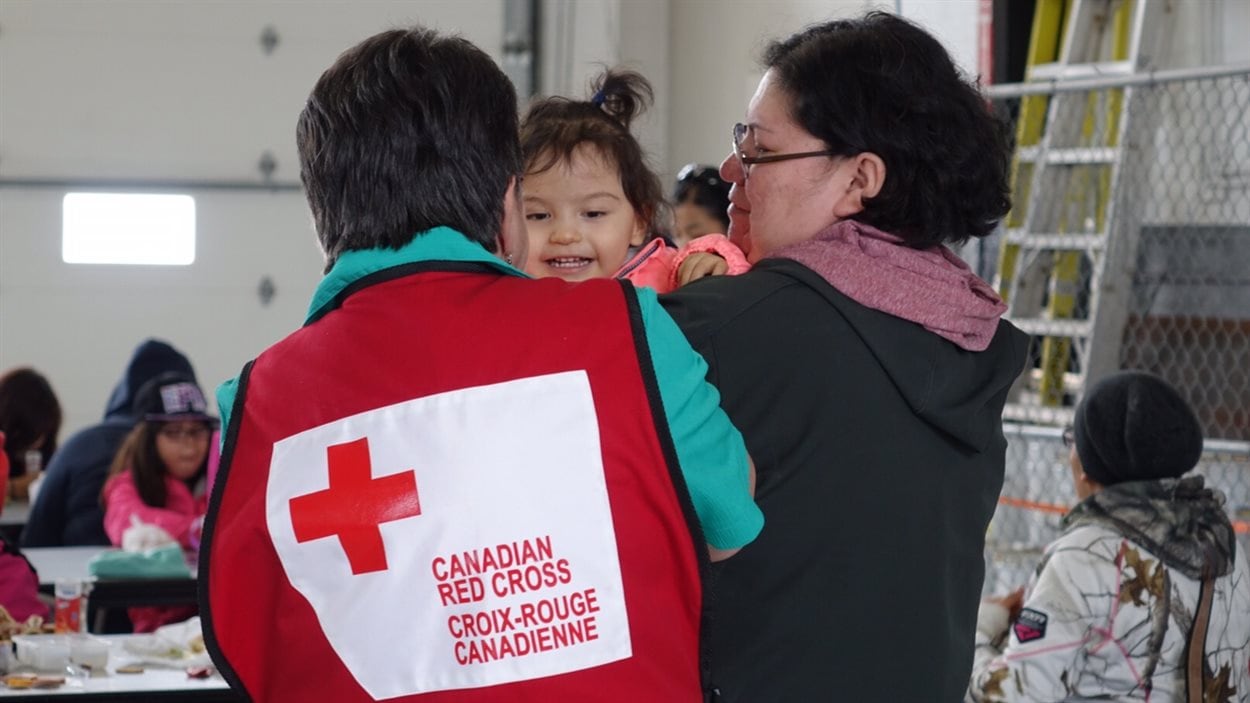 Les évacués reçoivent de l'aide de la Croix-Rouge.
