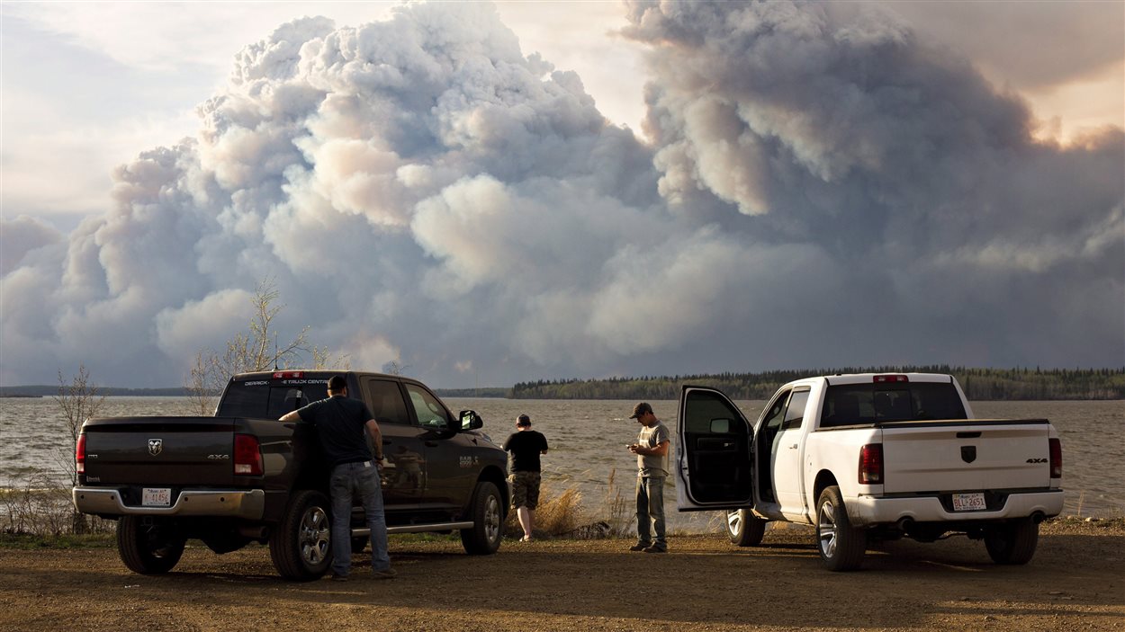 Des évacués observent à distance le feu de Fort McMurray.