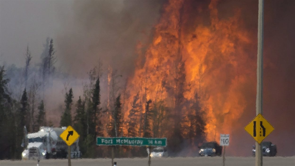 Des véhicules fuient vers le sud dans la chaleur d’un immense incendie ravageant la région de Fort McMurray, en Alberta.

