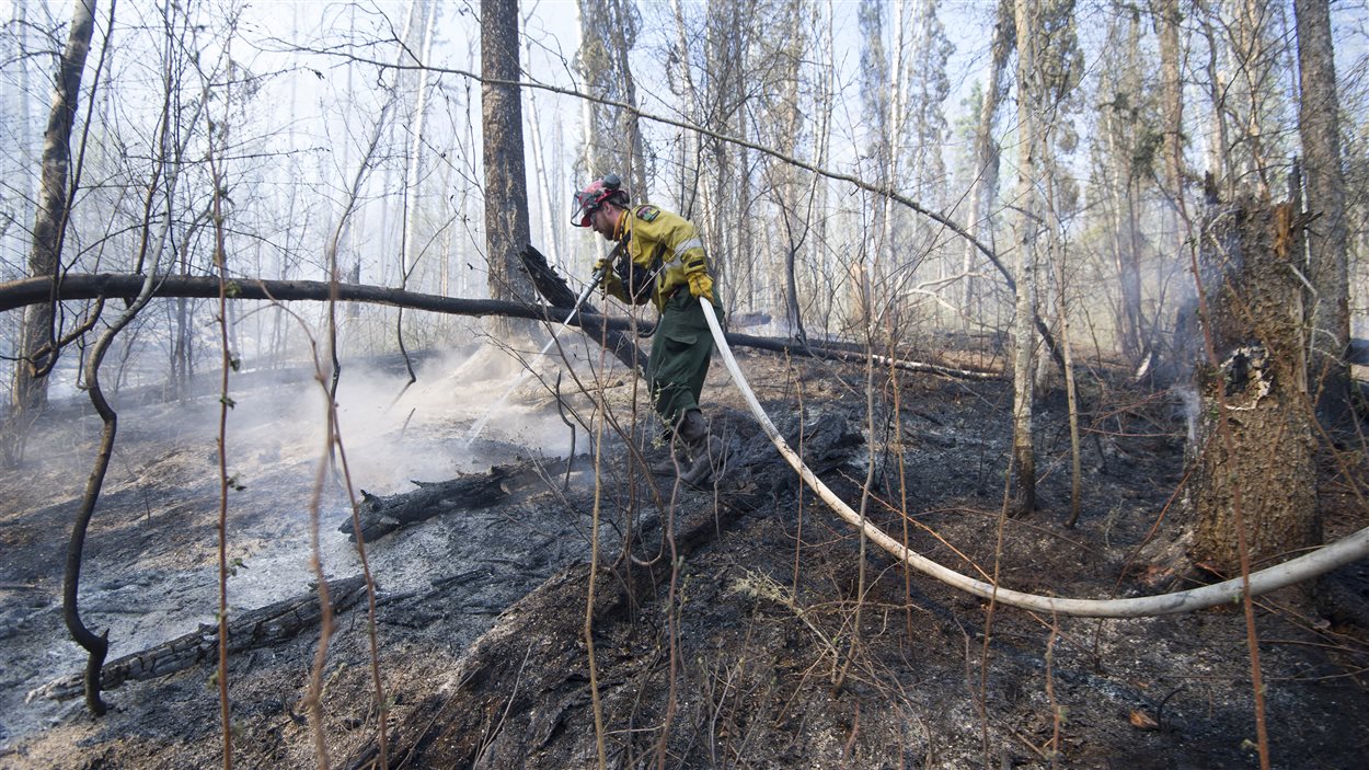 Un pompier lutte contre un feu de forêt près de Fort McMurray