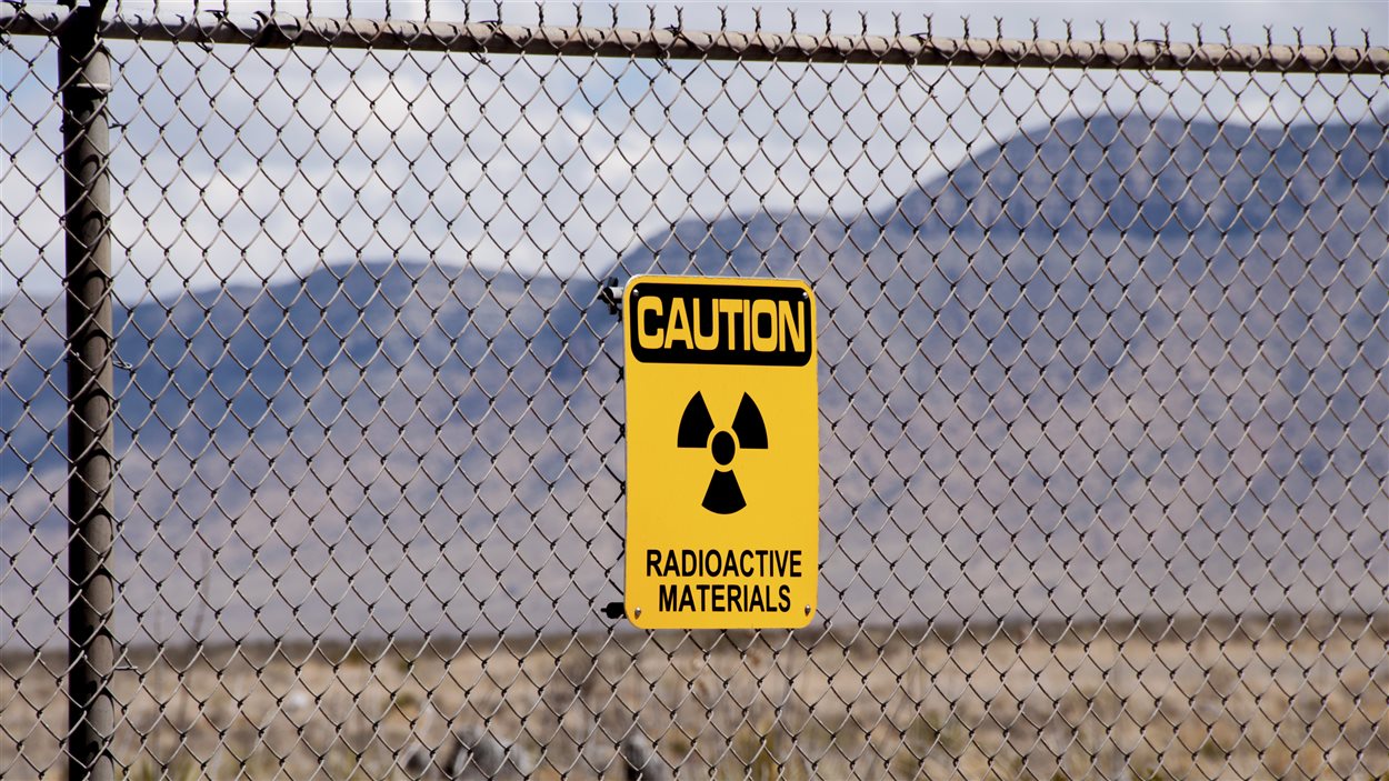 Un avertissement de matériaux radioactifs apposé à une clôture