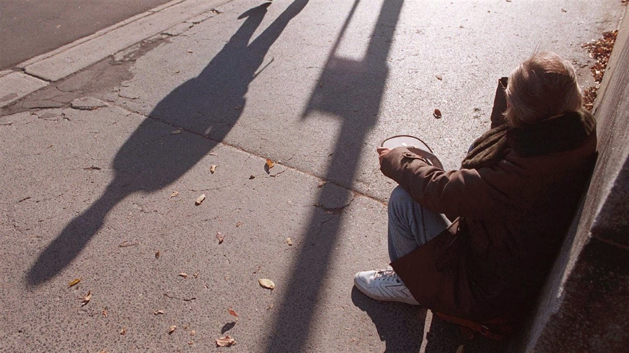 Une personne mendie dans une rue