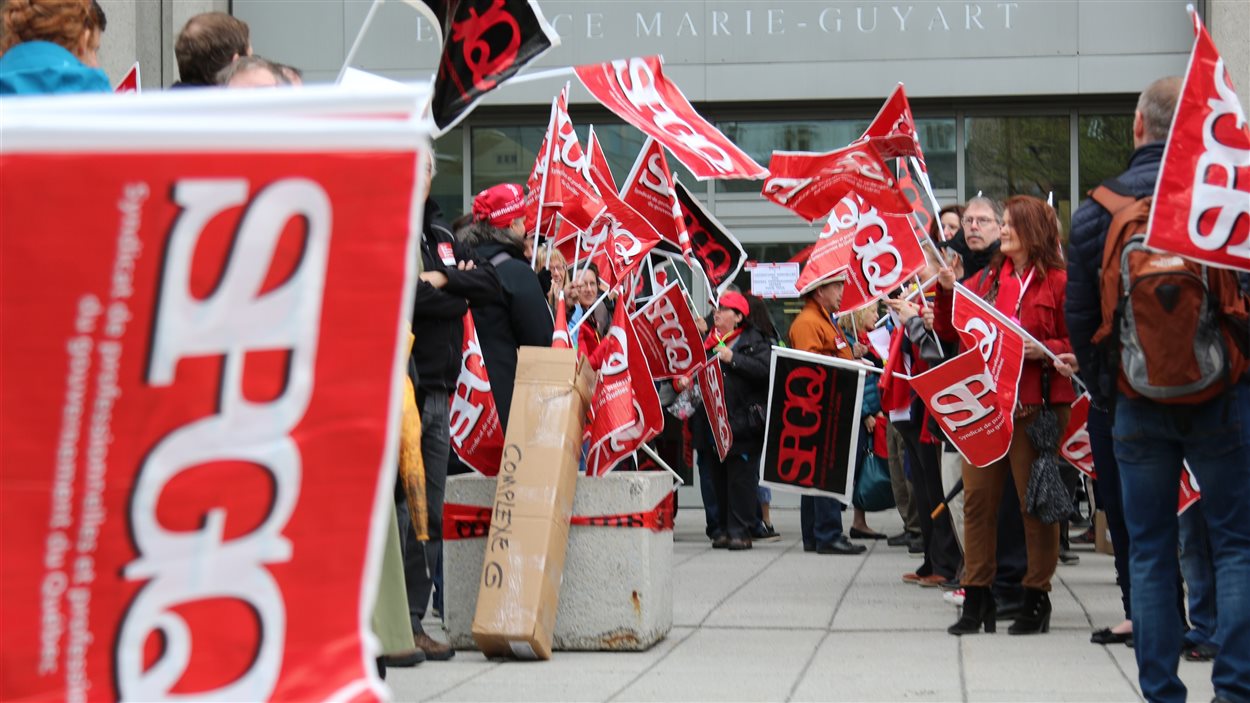 Des professionnels manifestent devant l'édifice Marie-Guyart à Québec.