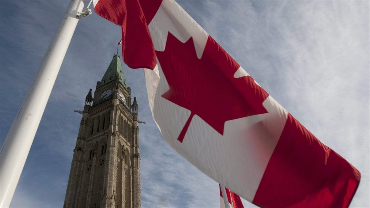 Un drapeau du Canada flotte au vent, sur la colline du Parlement, à Ottawa.