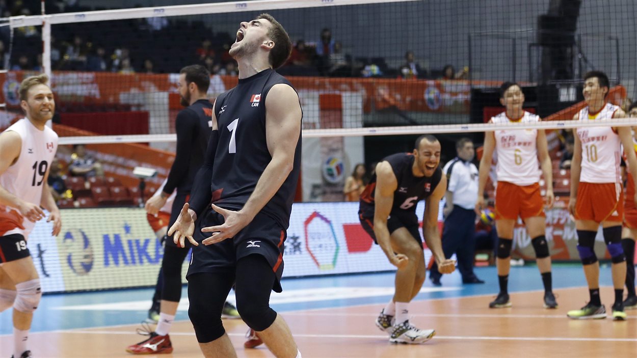 Les joueurs de l'équipe canadienne de volleyball, dont Tyler Sanders (no 1) célèbrent au Japon.