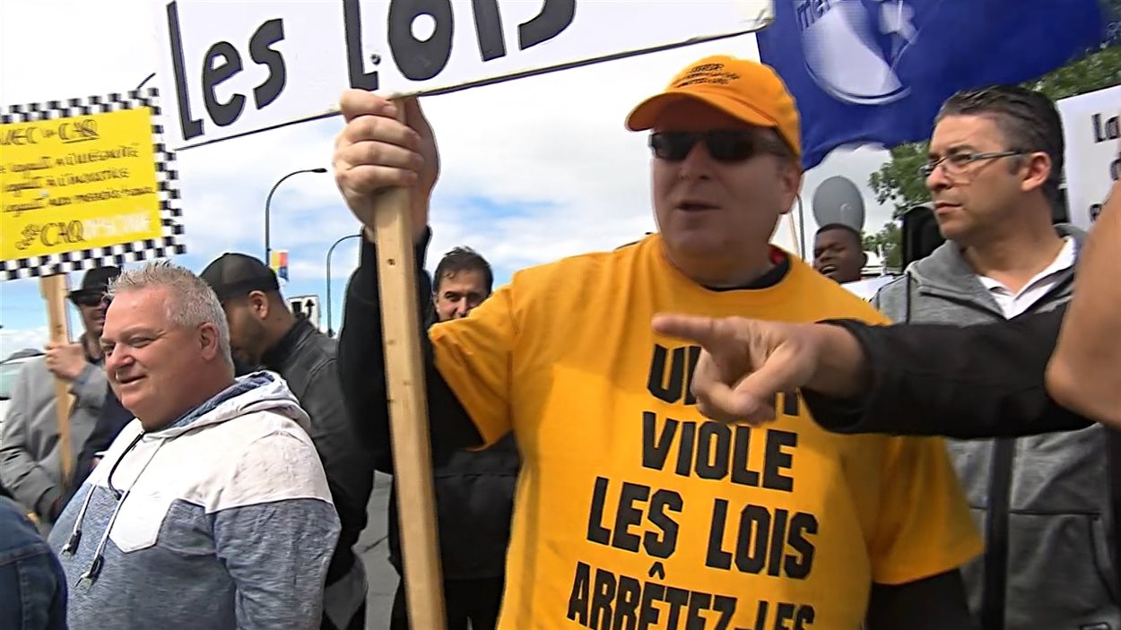 Des chauffeurs de taxi de Montréal, réunis près du site du site du Grand Prix du Canada, sur l'île Notre-Dame, veulent une adoption rapide du projet de loi 100.