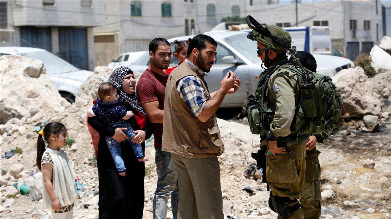 Un soldat israélien interdit l'entrée de la ville de Yatta à des Palestiniens.