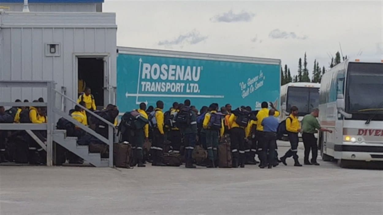 Les pompiers sud-africains en train de monter dans des autobus pour se rendre à Edmonton, samedi.