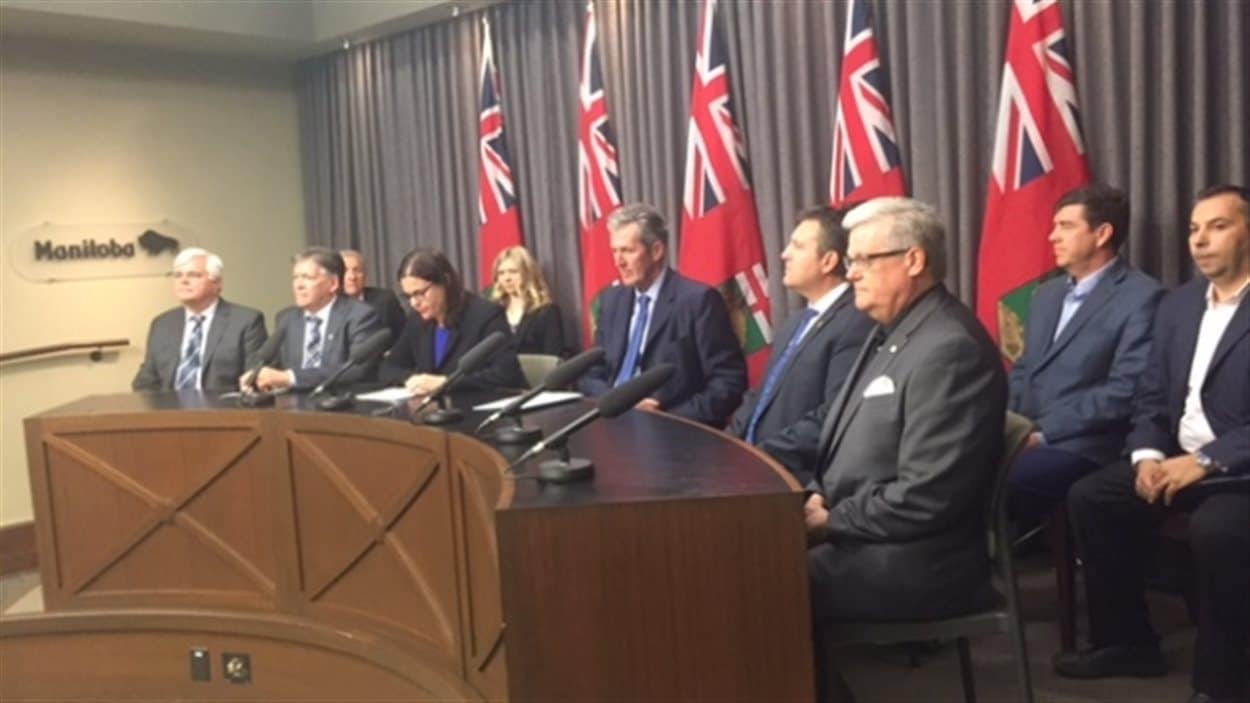 Le premier ministre du Manitoba, Brian Pallister, au centre est entouré de membres du gouvernement provincial et d'entrepreneurs pour exprimer son opposition au projet de loi C-10.