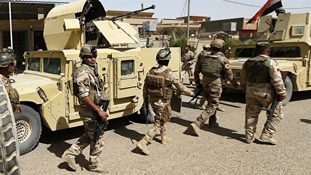 Des membres des forces gouvernementales irakiennes entrent dans le centre de la ville de Falloudja.