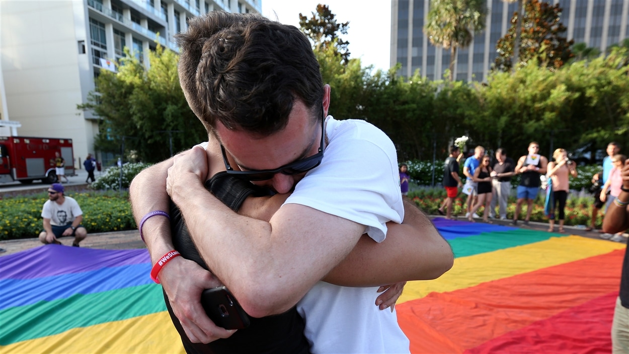 Deux hommes s'enlacent lors d'un rassemblement à Orlando en mémoire des victimes de la tuerie du club gai Pulse.